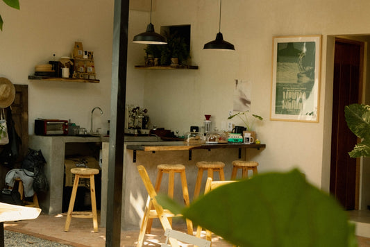 a kitchen with a table and stools and a potted plant
